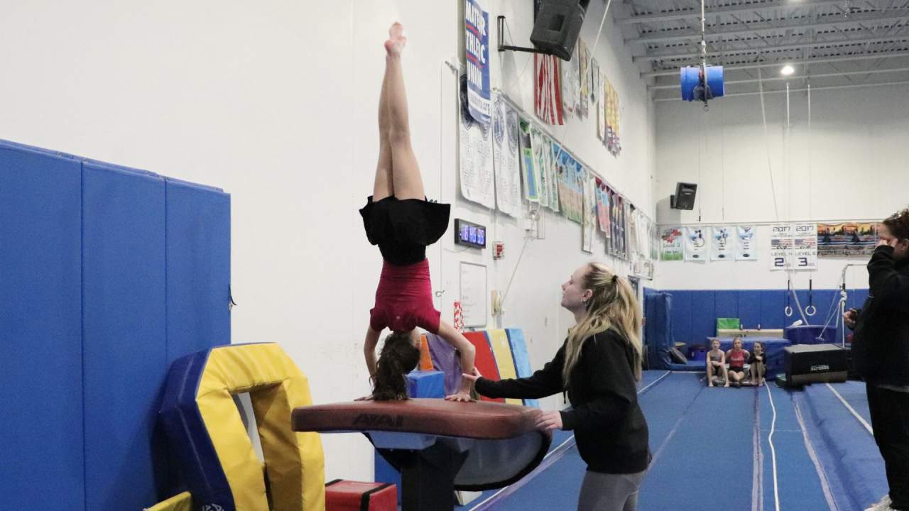 gymnast on vault with coach