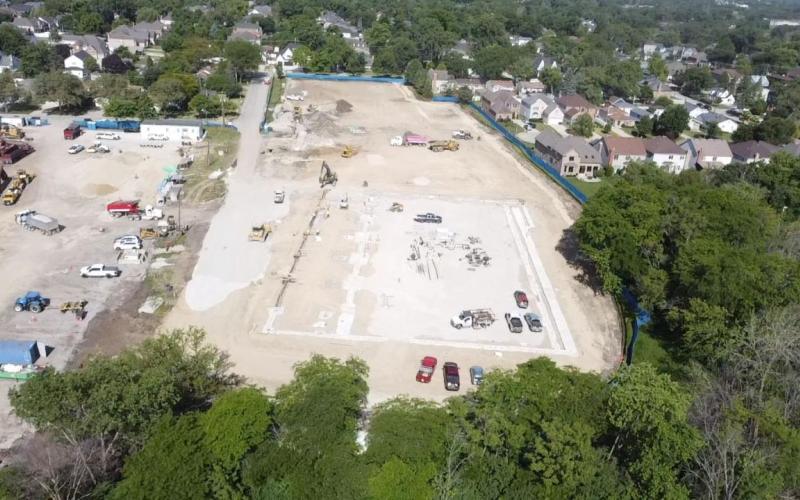 An aerial view of the Wagner construction site with various heavy machinery, trucks, and vehicles scattered across the cleared land. 