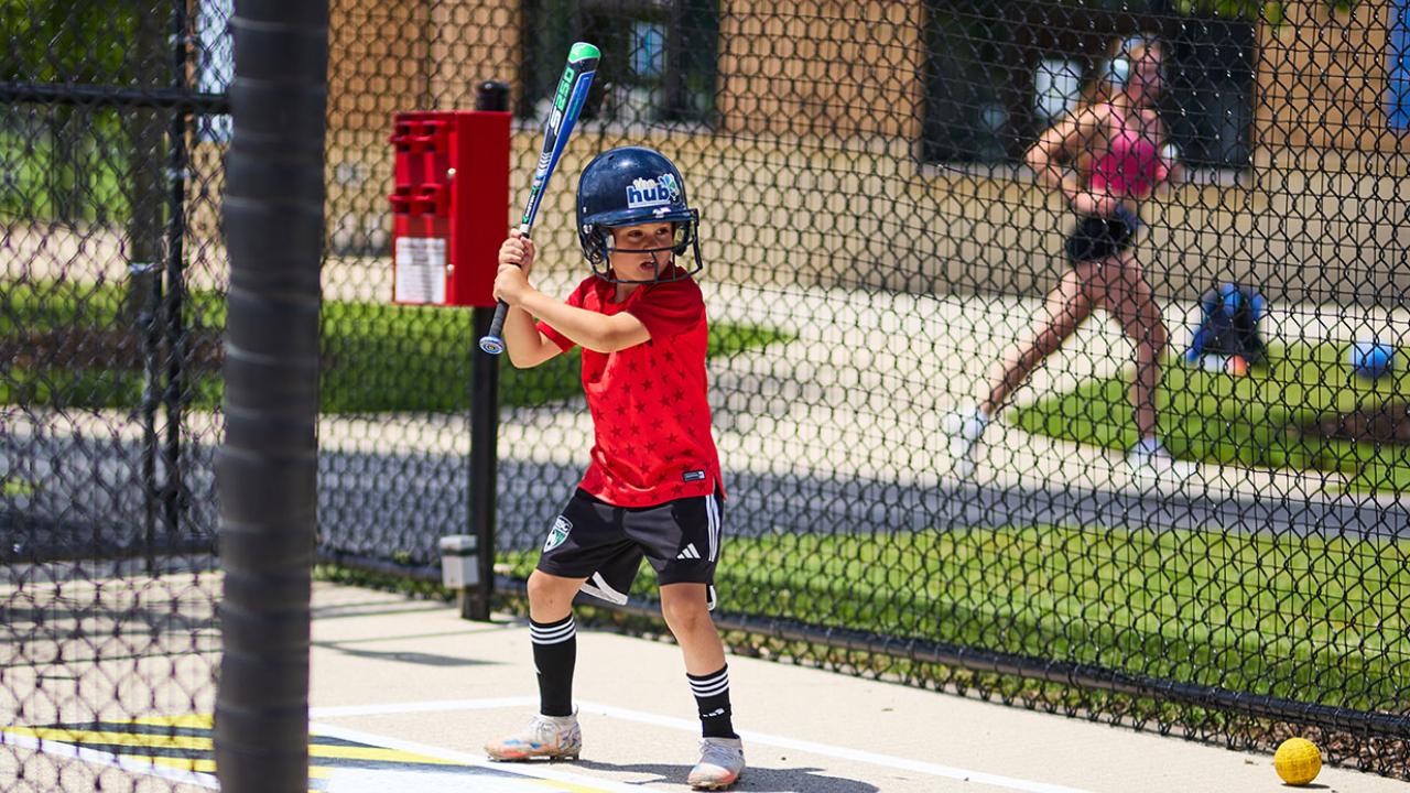 Boy with a bat inside a batting cage