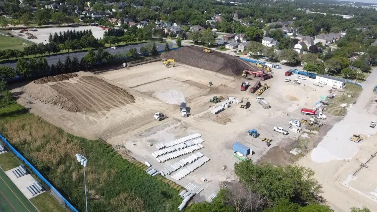 An aerial view of the Wagner construction site, Summer 2026. An aerial view of the Wagner construction site with heavy machinery, piles of dirt, and stacks of concrete pipes.