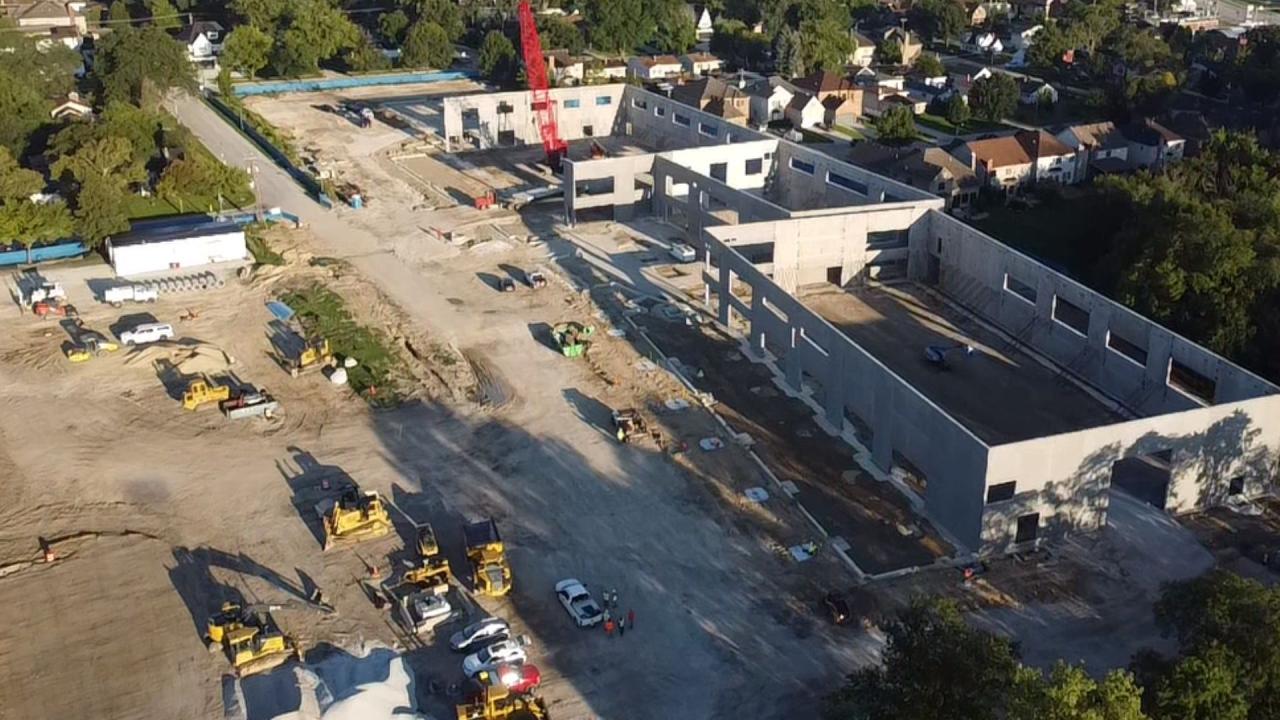 Aerial view of Wagner Community Center construction site with earthworks, construction vehicles and trucks, and partially built concrete buildings